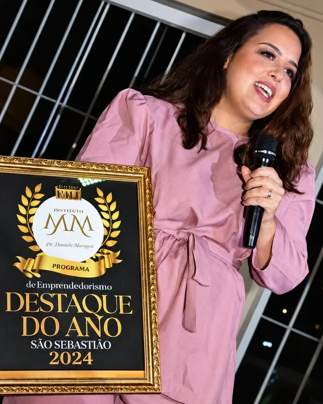 Dra. Marcella Marangon segurando a placa do prêmio Destaque do Ano 2024, em São Sebastião
